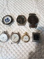 Group shot of all seven watches on quilted surface