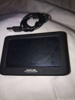 Front view of Magellan GPS and USB cable