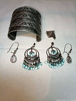 All four jewelry pieces laid out: cuff, earrings, ring