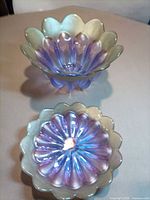 Top view of both iridescent glass bowls showing color and scalloped rims