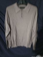 Front view of beige collared sweater on hanger