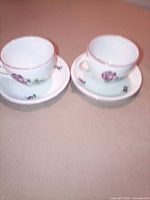 Full view of both cups on saucers showing set quantity and matching pattern
