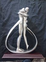 front view of silver resin embrace figurine on wooden base