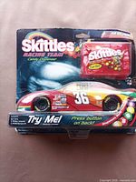 Front view of sealed Skittles Racing Team candy dispenser on blister card