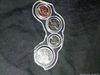 Front view of plastic holder showing four Canadian coins