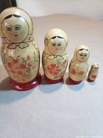 All four nesting dolls lined up in size order on tabletop