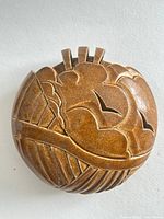 front view showing carved cloud and bird design, brown glaze