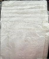 Stack of eight sealed white cotton tablecloth sets