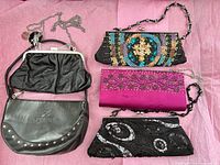 Overview of five clutch purses with chains on pink background