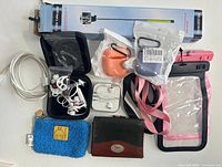 Overview of all items laid out including selfie stick box, cable, cases, pouches, wallet