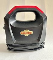 Front view of MotoMaster air compressor showing brand badge, carry handle, cord storage
