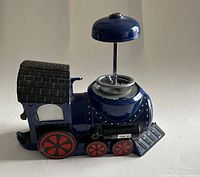 Left side view of blue train gumball machine showing body and missing globe