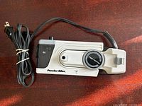 Top view of folded Proctor Silex travel iron with cord