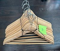 Stack of ten wooden hangers tied together, hooks visible