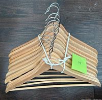 Stack of ten wooden hangers with metal hooks tied together