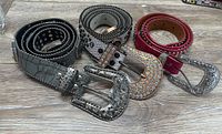 Four belts rolled showing buckles and rhinestone detail