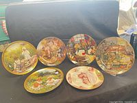 six decorative cat plates on display stand