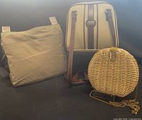 All three handbags: fabric cross-body, faux-leather purse, round wicker bag