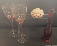 Group shot: two wine glasses, glass bottle with stopper, ceramic cat trinket box