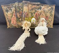 Four tapestry panels behind two tassel dolls, showing design and condition