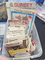 Plastic tote with assorted pattern envelopes and kits visible