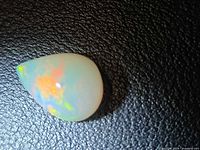 Front view of pear cabochon opal showing play-of-color