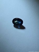 Front view of loose oval sapphire showing blue body with yellow-green tones