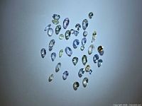 Group of multicoloured faceted tanzanite stones on white surface