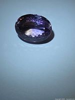 Top view of oval cut ametrine showing facets and colour zoning