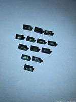 Thirteen rectangular blue-green sapphires arranged on white background