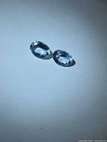 Pair of oval sky blue aquamarines on light background