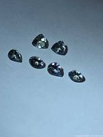 Six loose Tanzanite stones on white surface