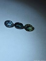 Three oval sapphires aligned on white surface
