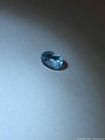 Top view of oval Swiss blue topaz on neutral background