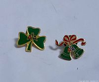 Front view of both enamel pins showing designs and colors