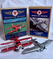 Two die-cast airplane banks with their original Wings of Texaco boxes
