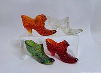 Group shot showing all four glass shoes on acrylic stand