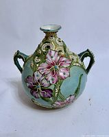 Front view showing floral design, handles, raised slip work