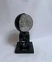 Front view showing moon globe, dial, calendar window and base