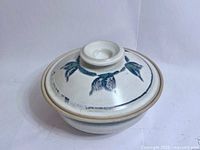 Lidded steamer front view showing leaf motif and glaze