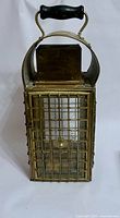 Full view of brass lantern front with wire grid and handle