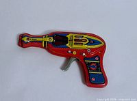 Left side view of tin litho space ray gun showing graphics and shape