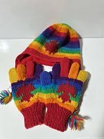 Rainbow knit hat and matching finger gloves laid flat showing colours and maple leaf motif