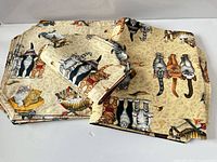 Stack of cat-print placemats, runner and smaller placemats
