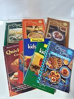 All eight cookbooks arranged, showing titles and bindings