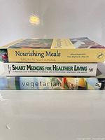 Stack of three health and cooking books showing titles on spines