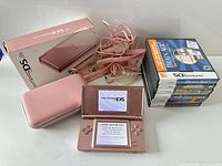 Entire lot: console powered on, accessories, box, stack of game cases