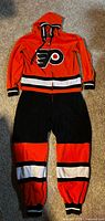 Front view of Flyers onesie showing logo, stripes, hood