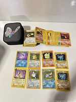 Stack of Pokémon cards and carry case displayed on table