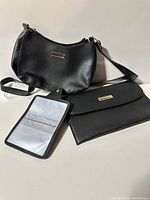 Overall view of black purse, envelope wallet and open zip pouch